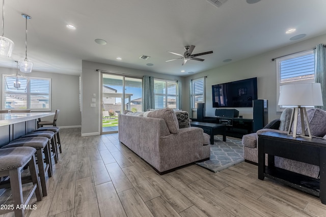 living room with ceiling fan and plenty of natural light