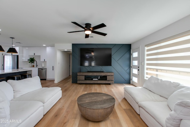 living area with a ceiling fan, recessed lighting, and light wood finished floors