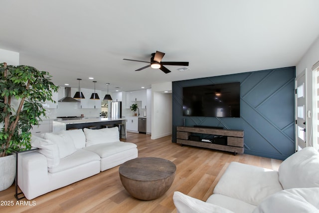 living area with light wood-type flooring, visible vents, ceiling fan, and recessed lighting