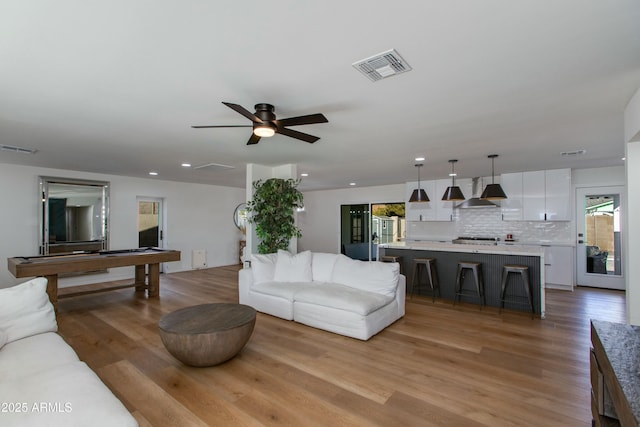 living room with a ceiling fan, recessed lighting, visible vents, and light wood finished floors