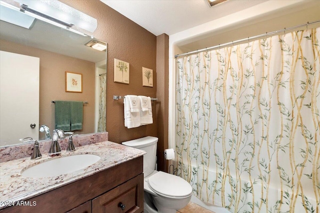 bathroom featuring toilet, vanity, a shower with shower curtain, and a skylight