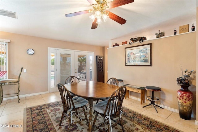 dining room with french doors, light tile patterned flooring, and ceiling fan