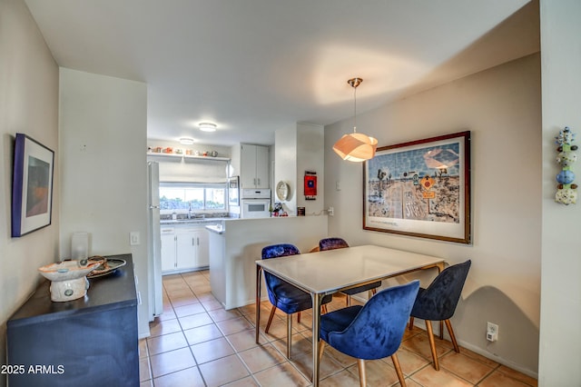 dining area featuring sink and light tile patterned flooring