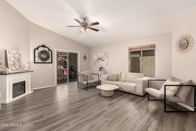 7826 W Mcrae Way, Glendale, AZ 85308 - living room featuring vaulted ceiling, ceiling fan, wood finished floors, a glass covered fireplace, and baseboards
