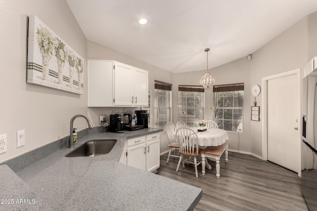 7826 W Mcrae Way, Glendale, AZ 85308 - kitchen with a sink, vaulted ceiling, white cabinetry, a chandelier, and wood finished floors