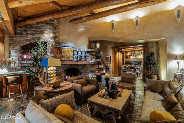 living room featuring beamed ceiling, wood ceiling, a fireplace, and a high ceiling