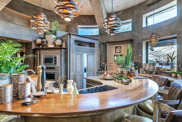 kitchen with a towering ceiling and built in appliances