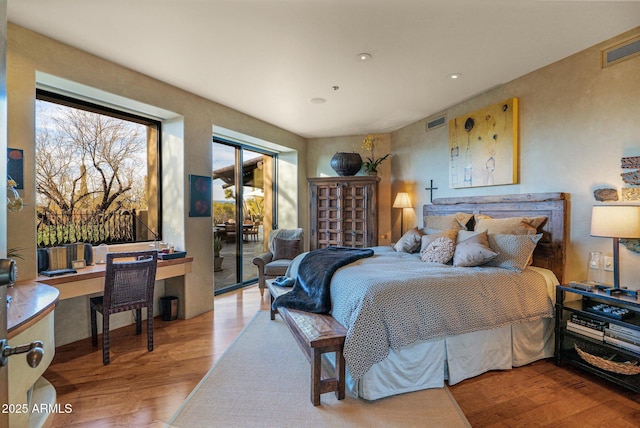 bedroom featuring access to exterior and light wood-type flooring