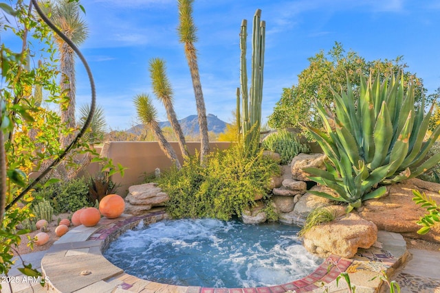 view of pool with a small pond and a mountain view