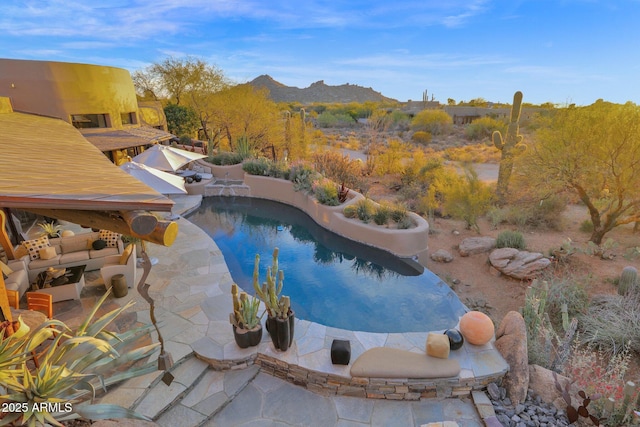 view of pool with a patio, a mountain view, and an outdoor hangout area