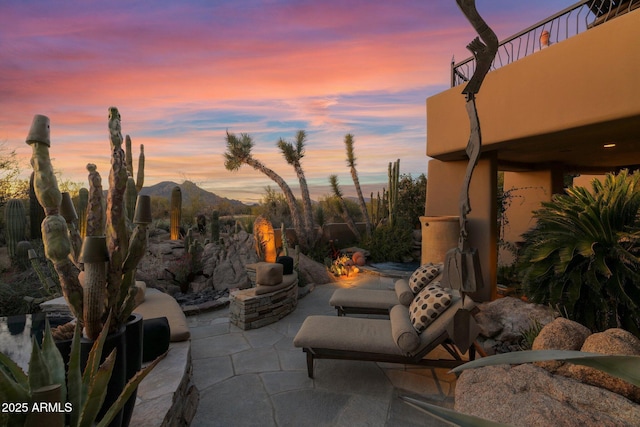 patio terrace at dusk featuring a mountain view