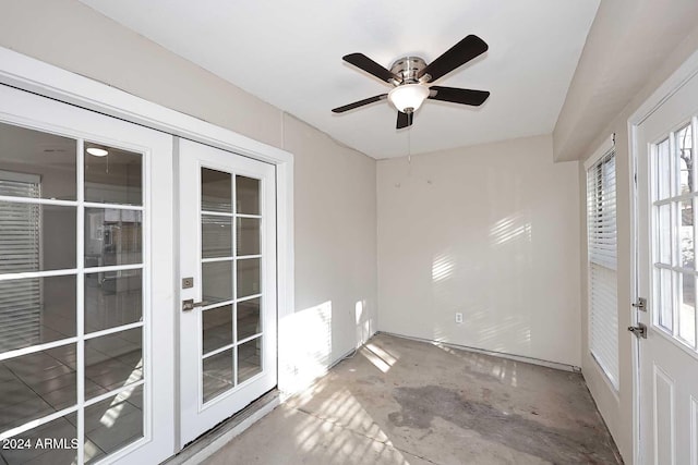 empty room featuring ceiling fan, french doors, and concrete floors