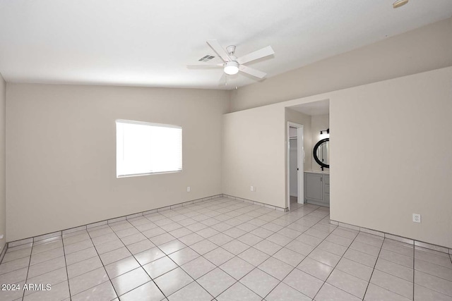 unfurnished room featuring ceiling fan, light tile patterned floors, and vaulted ceiling