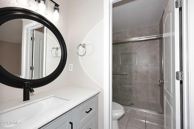 bathroom featuring tile patterned floors, vanity, toilet, and a shower with door