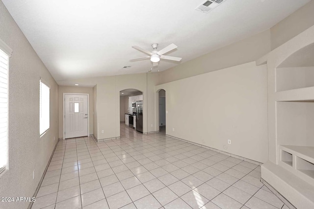 unfurnished living room with light tile patterned floors and ceiling fan