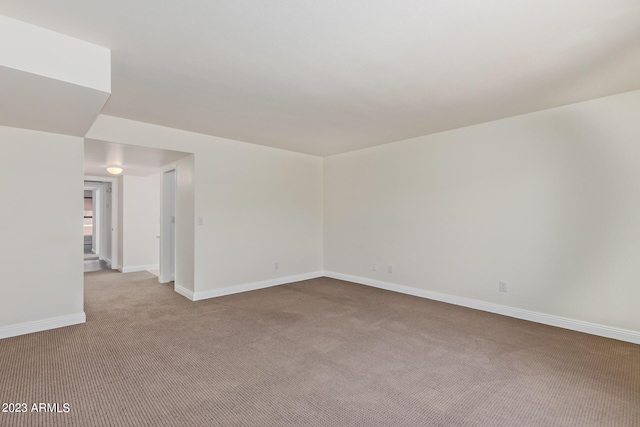 spare room with baseboards and carpet floors