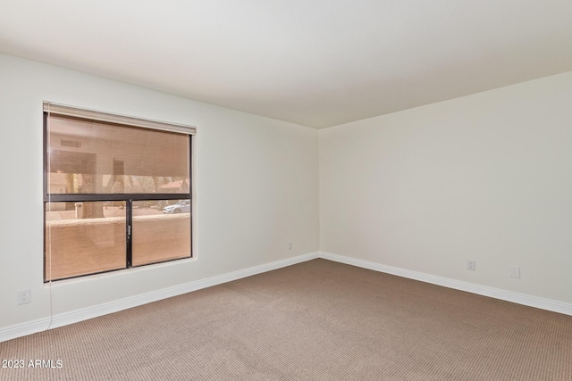 empty room with baseboards and carpet flooring