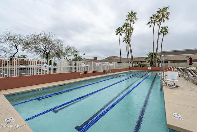 view of swimming pool featuring fence