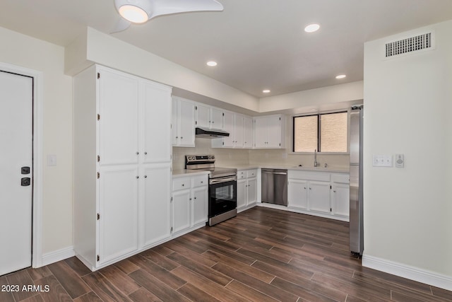 kitchen featuring visible vents, dark wood-style flooring, stainless steel appliances, and under cabinet range hood