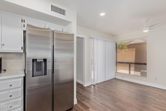 kitchen featuring white cabinets, visible vents, baseboards, wood finished floors, and stainless steel fridge