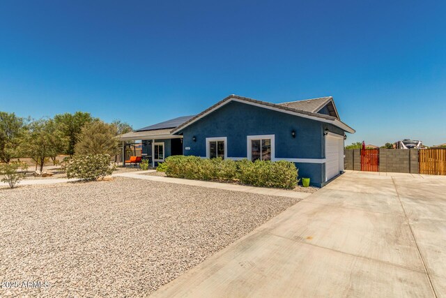 5321 N 196th Ave, Litchfield Park, AZ 85340 - view of front of property featuring concrete driveway, roof mounted solar panels, an attached garage, and stucco siding