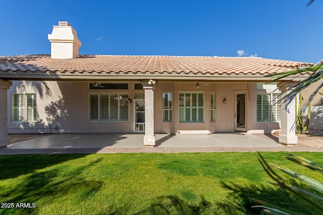 rear view of house with a yard, ceiling fan, and a patio area