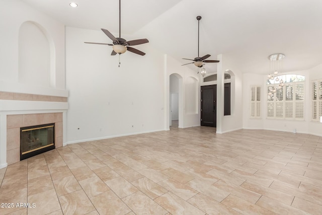 unfurnished living room featuring a tile fireplace and ceiling fan