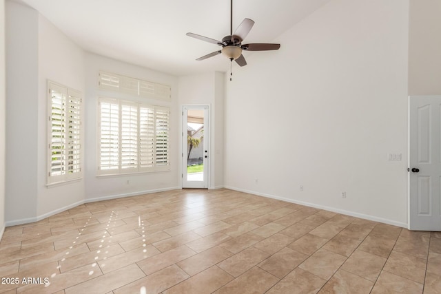 empty room featuring ceiling fan and a high ceiling