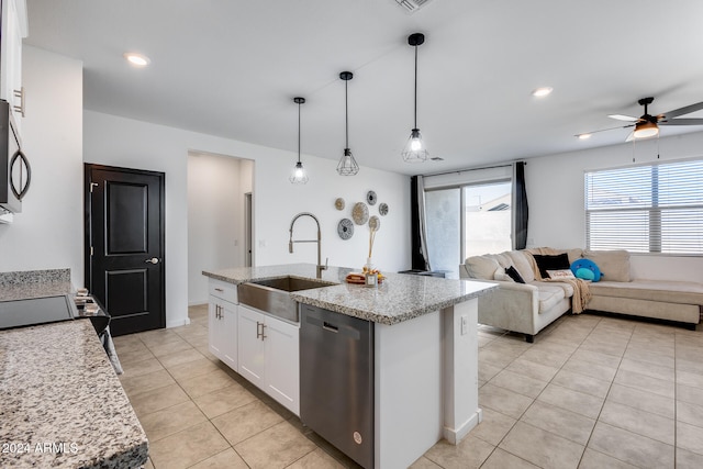 kitchen featuring stainless steel appliances, a center island with sink, sink, decorative light fixtures, and white cabinets