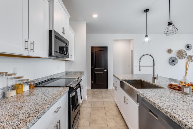 kitchen with white cabinetry, light stone counters, and stainless steel appliances