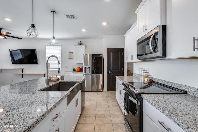 kitchen featuring sink, appliances with stainless steel finishes, light stone countertops, white cabinets, and pendant lighting