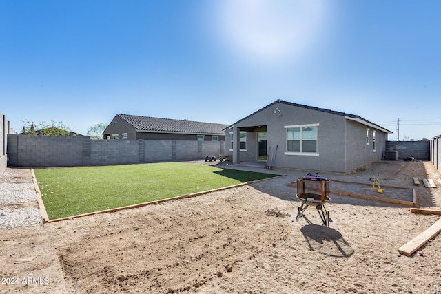 back of house featuring a patio and a lawn