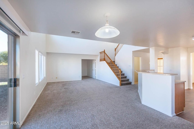 unfurnished living room with dark colored carpet