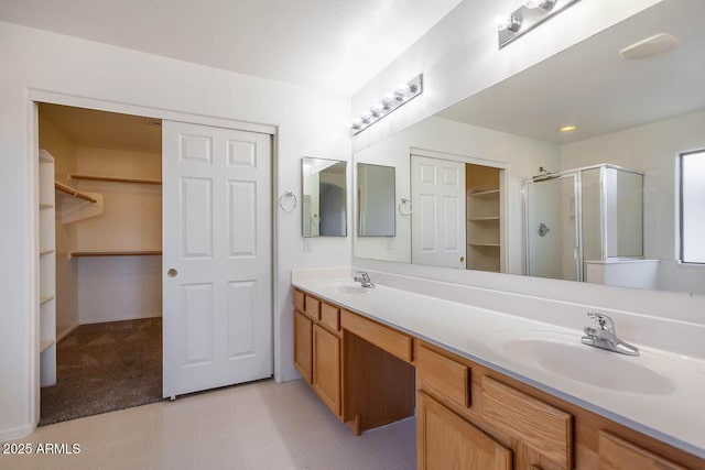 bathroom featuring a shower with door and vanity