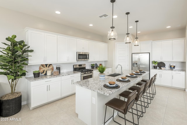 kitchen featuring a kitchen island with sink, sink, white cabinetry, and stainless steel appliances