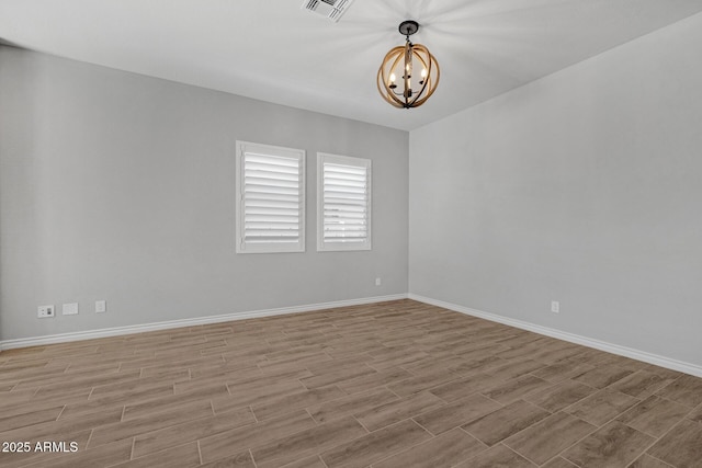 unfurnished room featuring an inviting chandelier