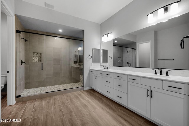 bathroom featuring vanity, toilet, and an enclosed shower