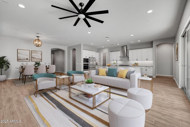 living room featuring sink and ceiling fan with notable chandelier