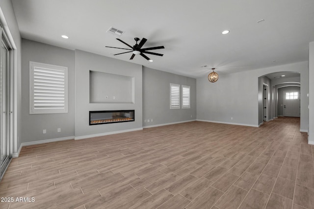 unfurnished living room with ceiling fan and a healthy amount of sunlight