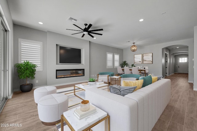 living room with ceiling fan and a healthy amount of sunlight