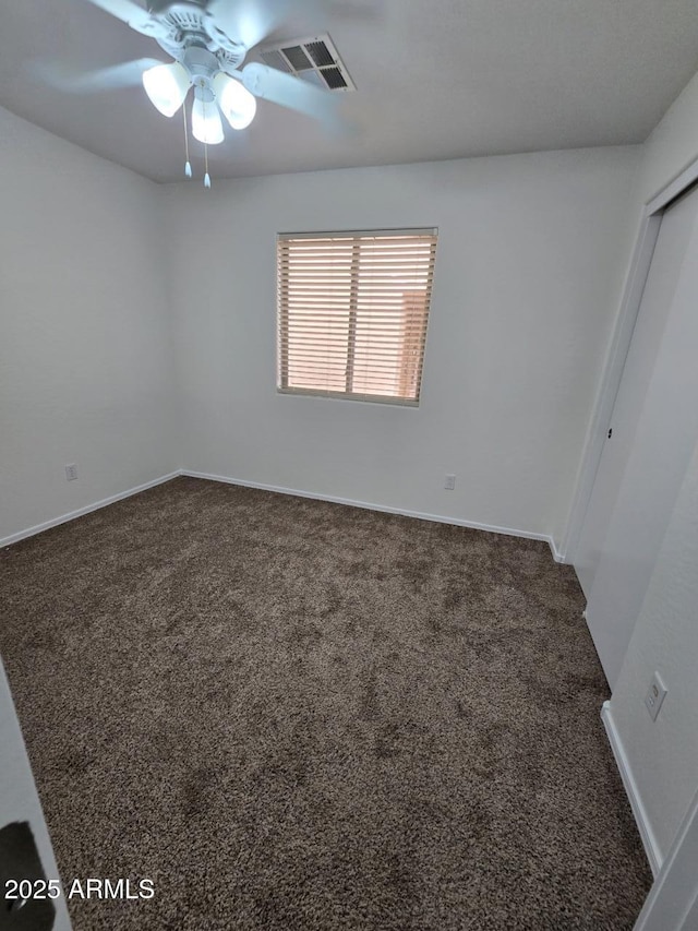 unfurnished bedroom with ceiling fan and dark carpet