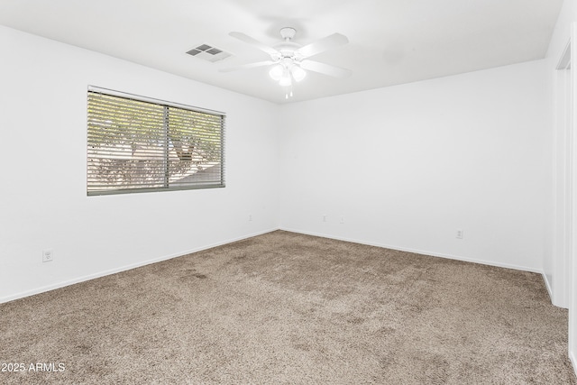 unfurnished room with ceiling fan and carpet