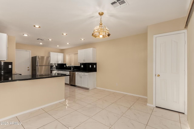 kitchen featuring a chandelier, white cabinets, sink, decorative light fixtures, and stainless steel appliances