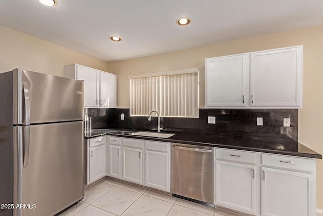 kitchen with sink, white cabinets, decorative backsplash, and stainless steel appliances