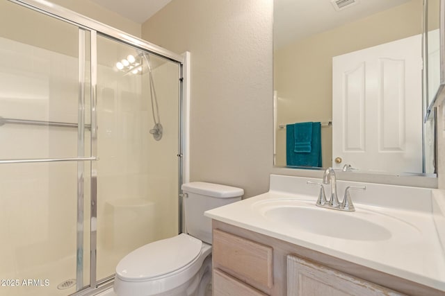 bathroom featuring vanity, toilet, and walk in shower