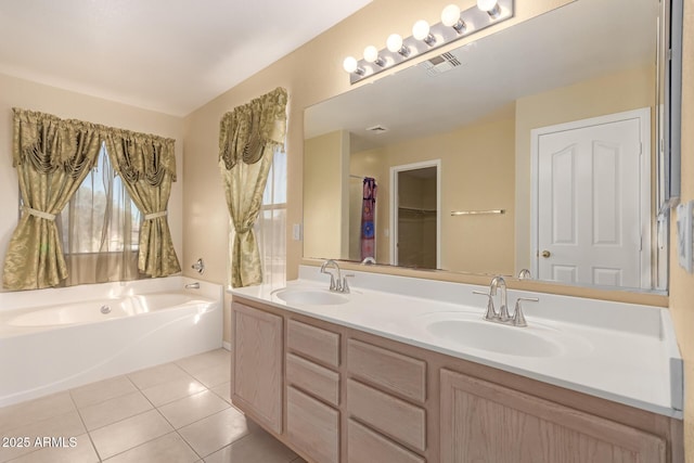 bathroom featuring a healthy amount of sunlight, tile patterned flooring, a tub to relax in, and vanity