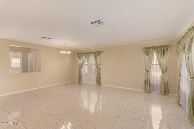 empty room with a chandelier and plenty of natural light