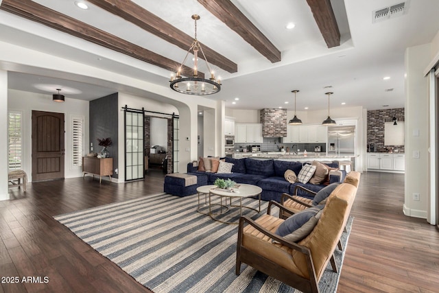 12834 W Forest Pleasant Pl, Peoria, AZ 85383 - living room featuring a barn door, dark wood-type flooring, beam ceiling, a chandelier, and recessed lighting