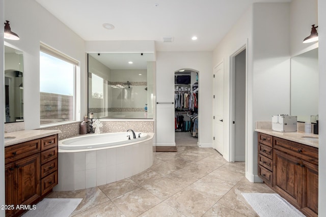 12834 W Forest Pleasant Pl, Peoria, AZ 85383 - full bathroom featuring a tile shower, a bath, vanity, and a spacious closet