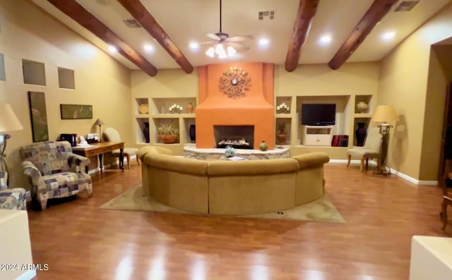 living room with ceiling fan, hardwood / wood-style floors, and beam ceiling